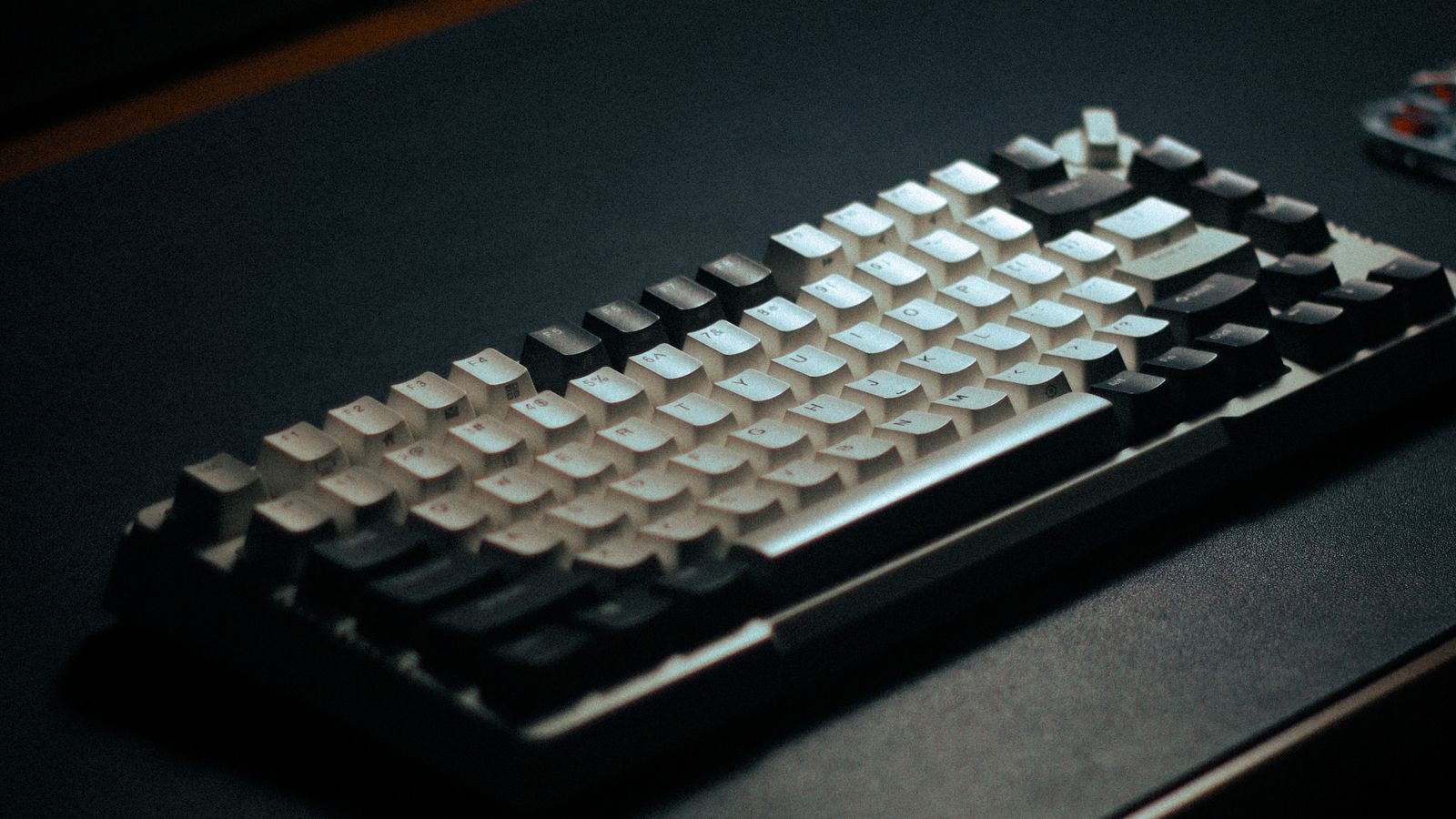 A backlit mechanical keyboard glowing on a dark desk, representing ready-to-run Claude Code prompts