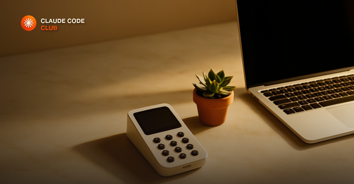 A card reader terminal beside a laptop on a clean marble desk, warm afternoon light