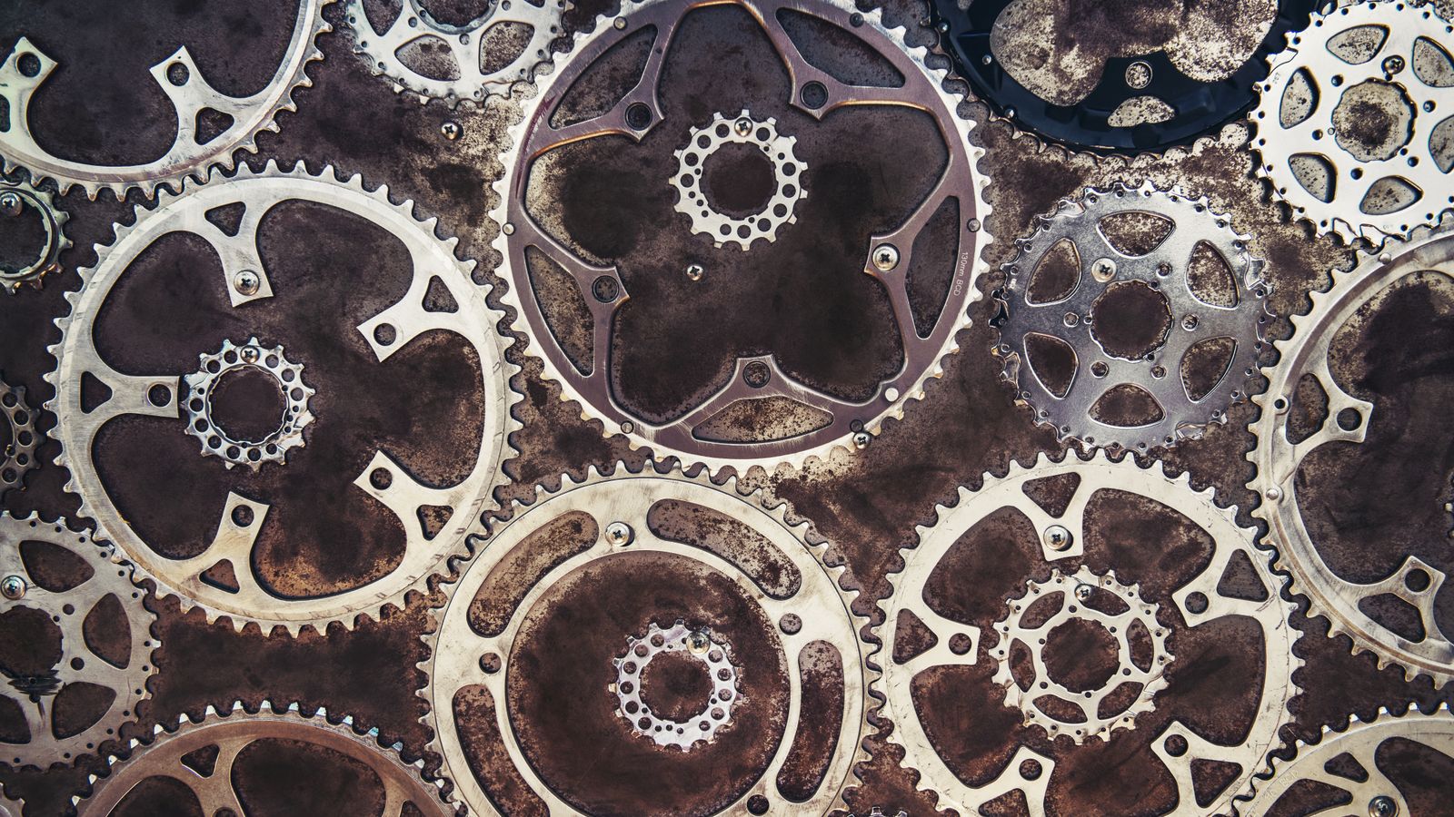 Interlocking golden and metal gears on a dark surface, representing business automations