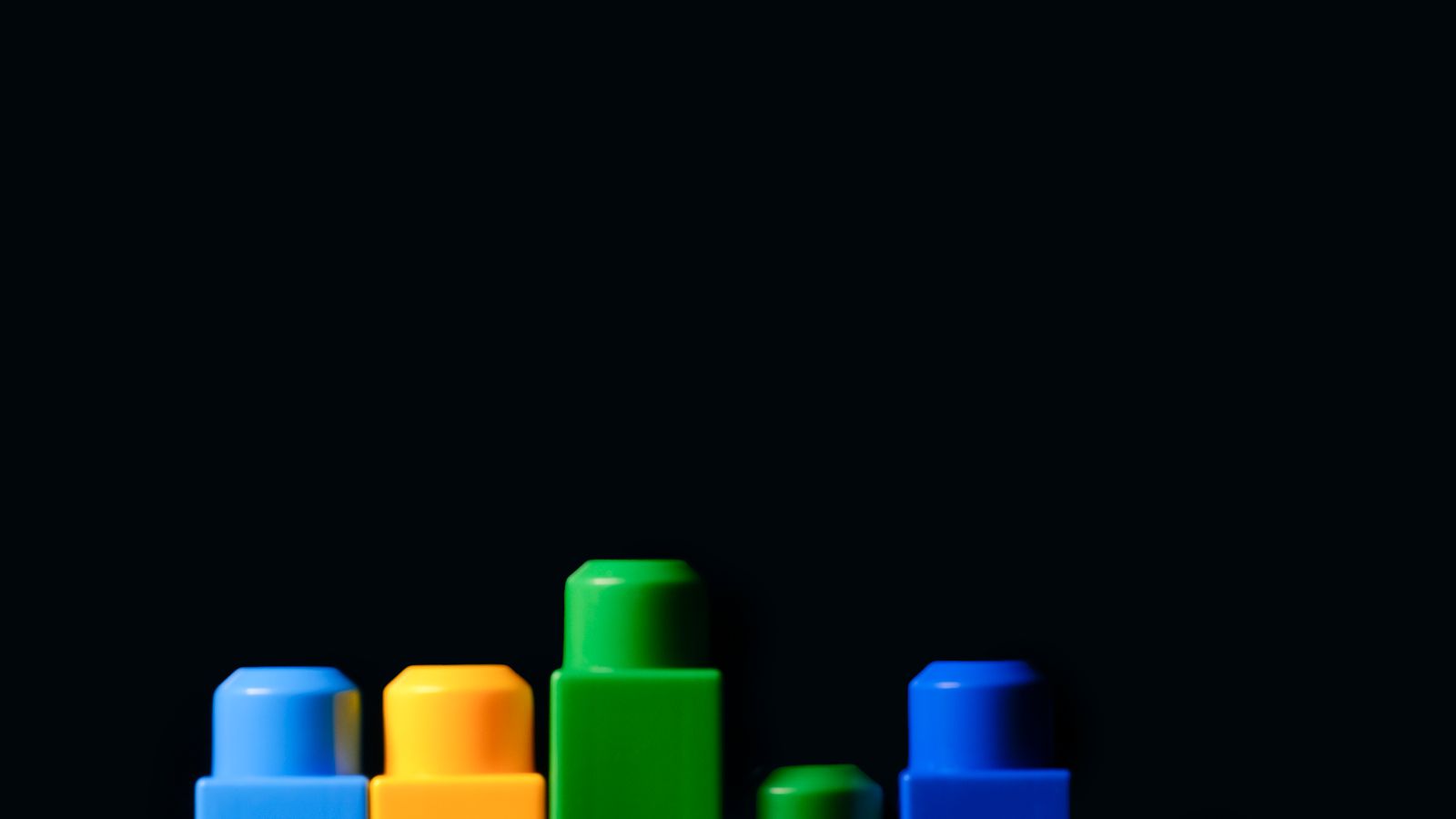 Colorful modular building blocks of different heights on a black background, representing installable plugins