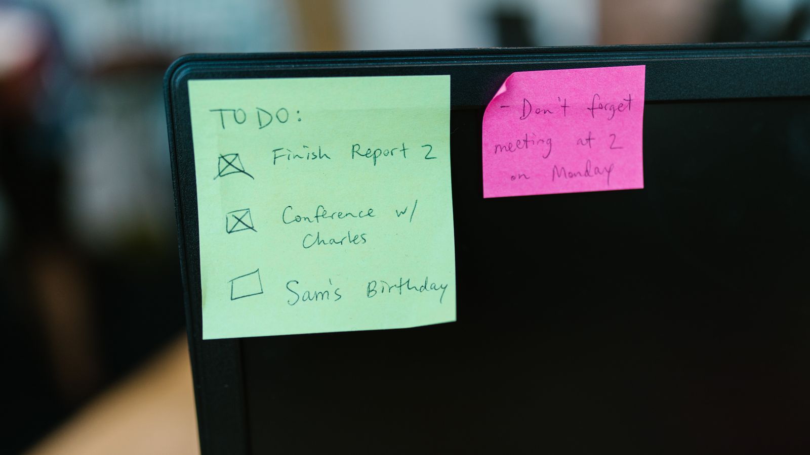 Colorful handwritten sticky notes on the edge of a monitor, representing a quick-reference cheat sheet