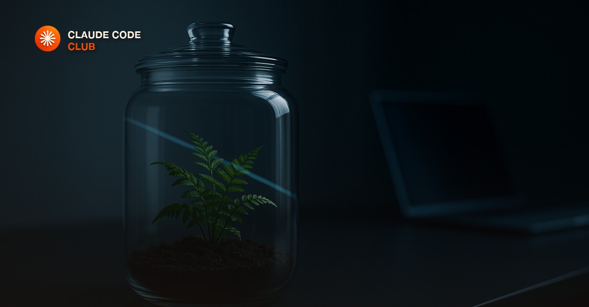 A glass terrarium sitting on a desk next to a laptop, with a small potted plant sealed inside and a single beam of light crossing the glass