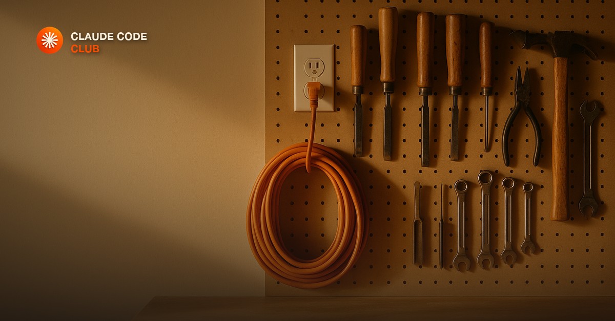 A woodworker's pegboard wall in warm light with a coiled orange extension cord on one side and neatly hung hand tools on the other.