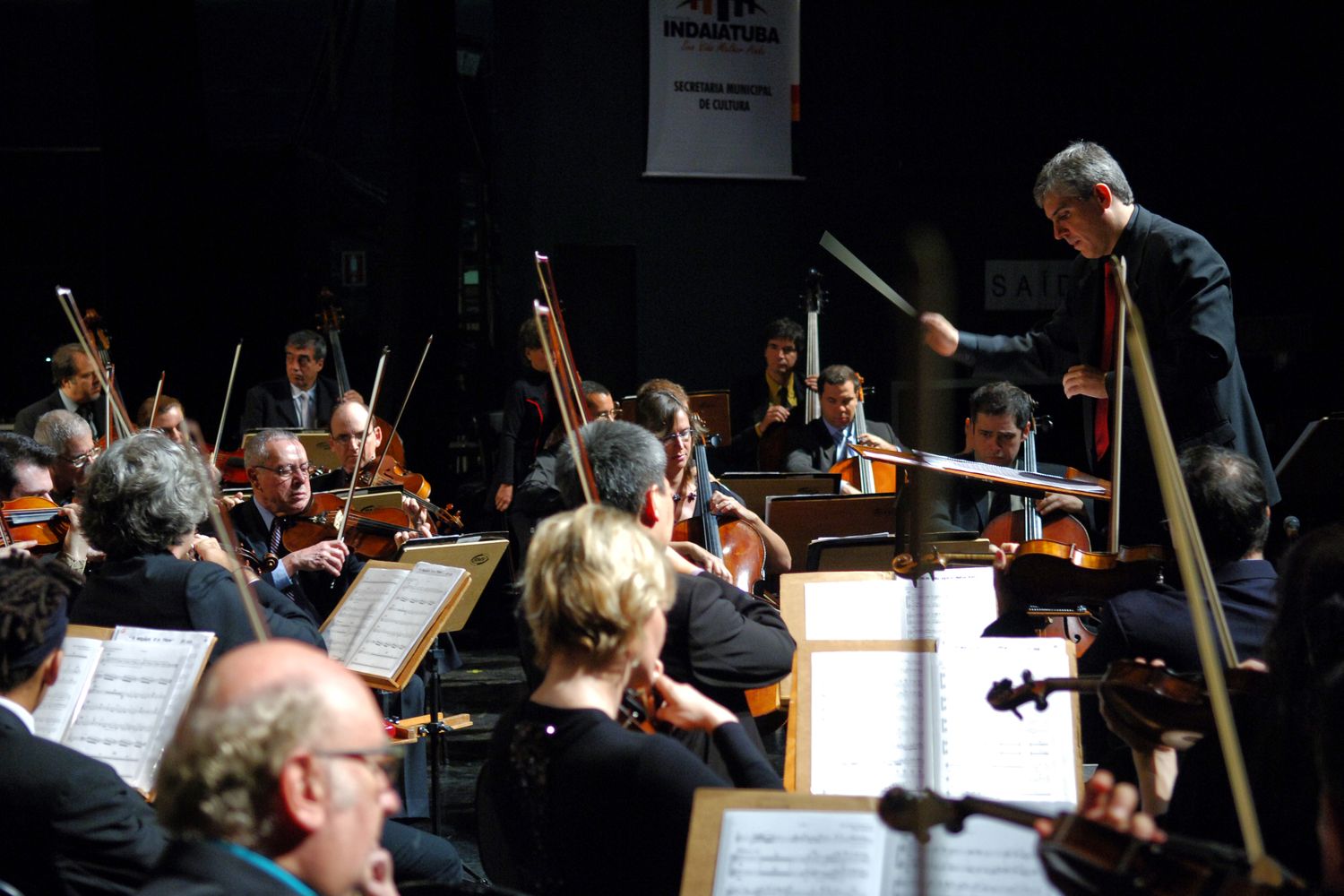 A conductor directing a full orchestra while each section plays its own part, a metaphor for one main agent orchestrating Claude Code subagents