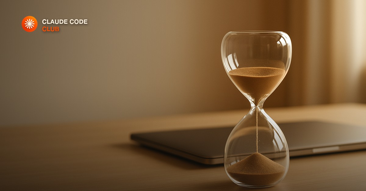 An hourglass paused beside a closed laptop on a quiet desk, warm afternoon light, a pause in the middle of a workflow