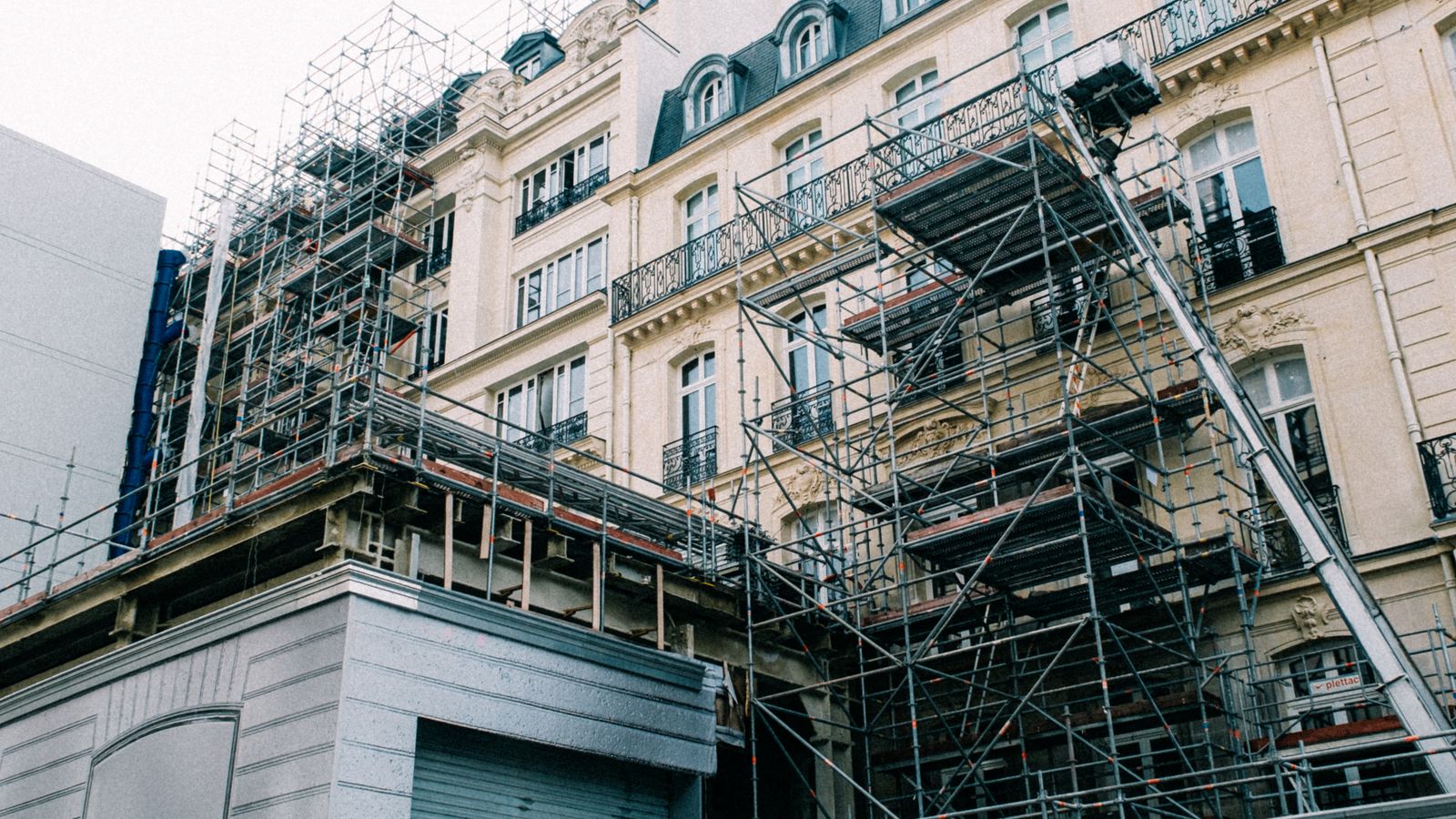 An old ornate building wrapped in construction scaffolding during a renovation