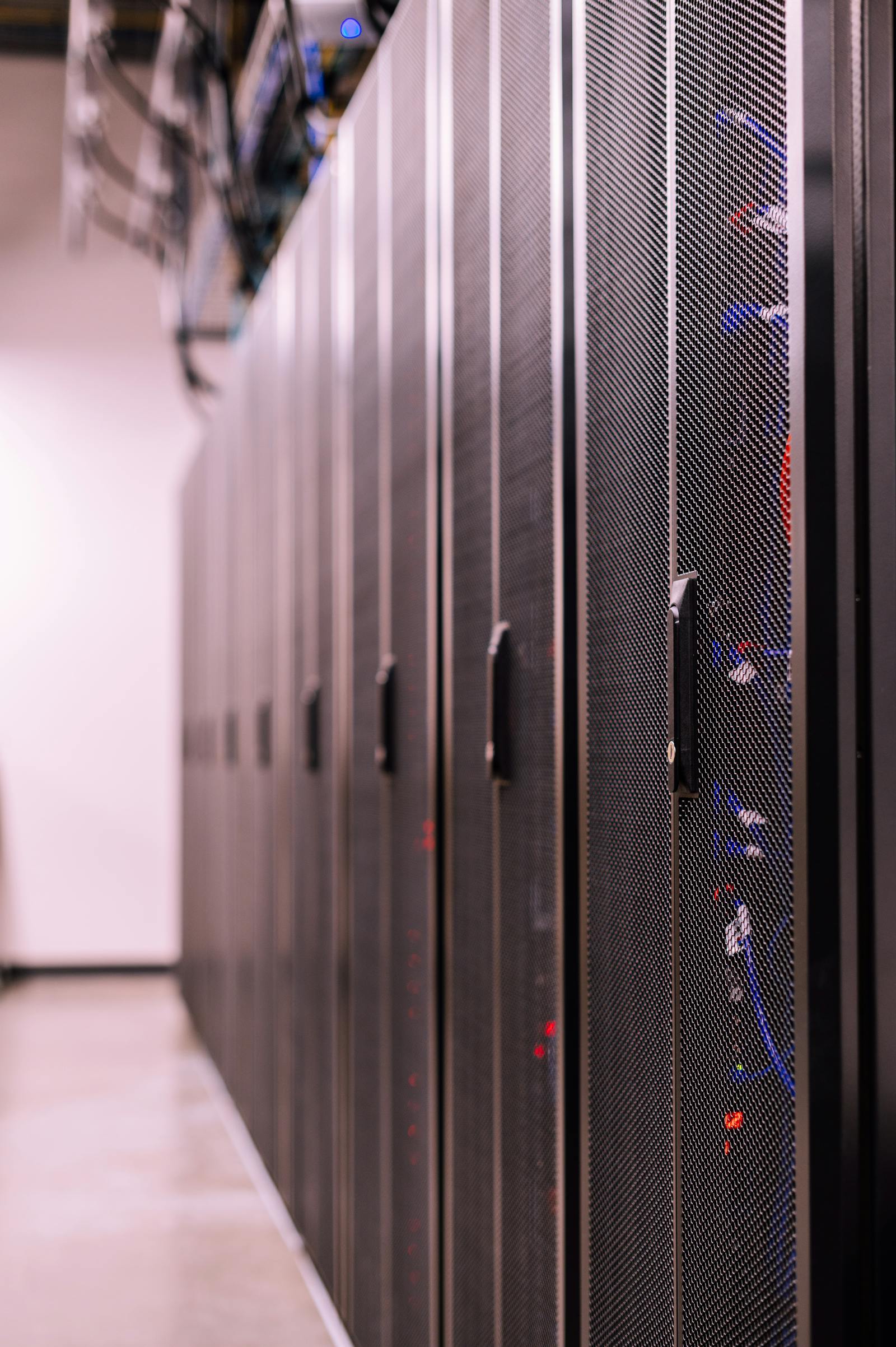 Black server racks in a data center with cables routed between hardware units