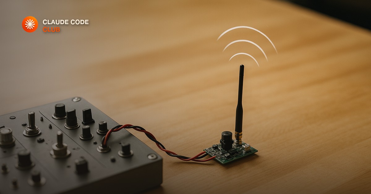 A small custom-built radio transmitter wired into a larger control panel, sending a signal outward on a clean workbench