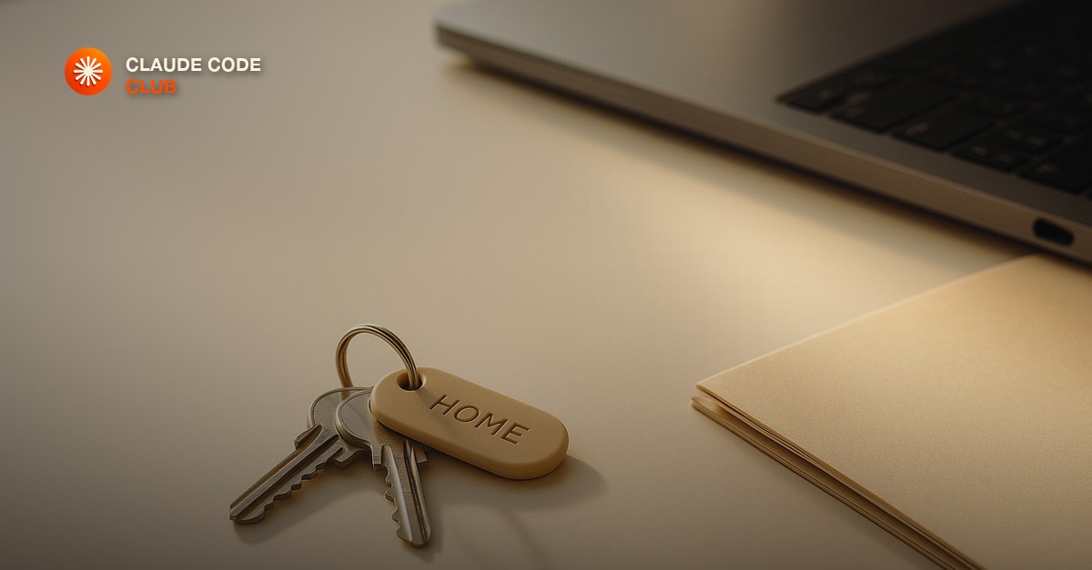 A labeled set of keys being set down on a clean desk beside a closed laptop and a tidy folder in warm morning light